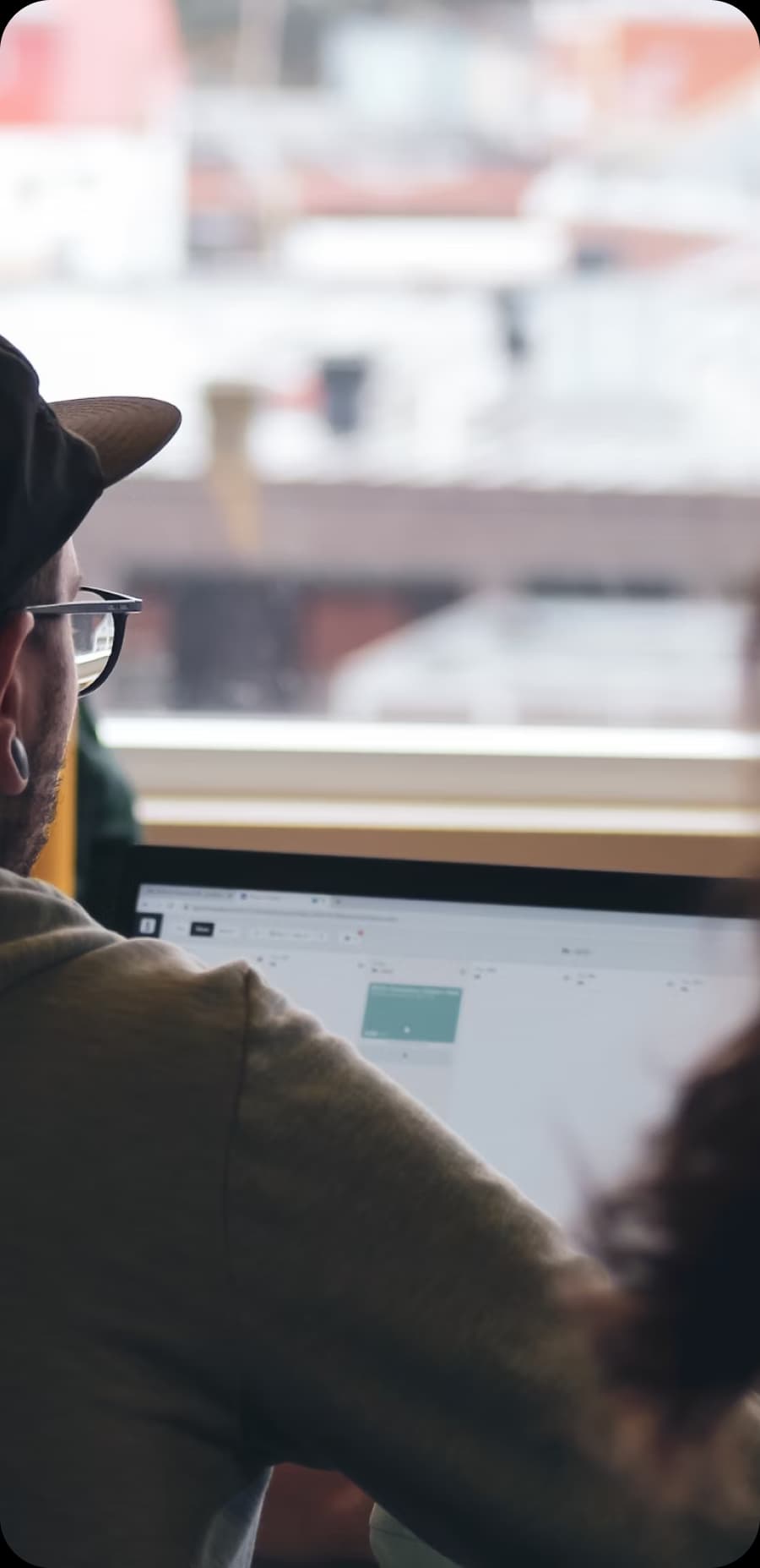 Man wearing glasses looking at a computer screen.
